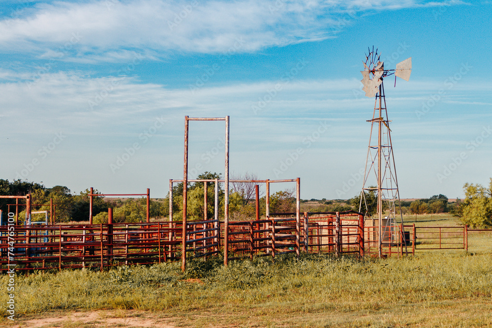 Texas Ranch and Windmill with blue sky and green grass in summer Texas Ranch and Windmill with blue sky and green grass in summer