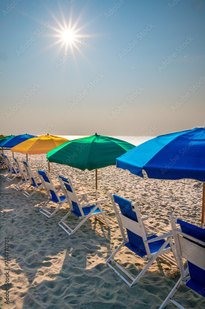 Ready for relaxing under colorful beach umbrellas in beach chairs on the beach
