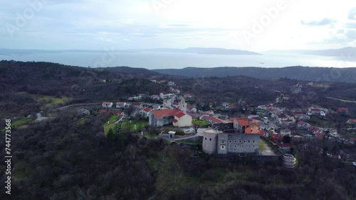 Aerial view of the charming village of Grobnik near Rijeka, Croatia, showcasing an old fortress atop a hill and a quaint church photo