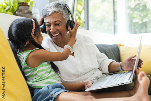 Biracial girl shares a moment with her grandmother at home photo