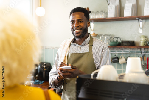 African American barista serves coffee at a cozy cafe photo