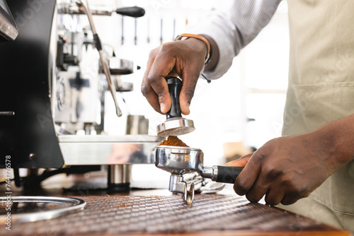 African American barista prepares espresso at a coffee shop photo