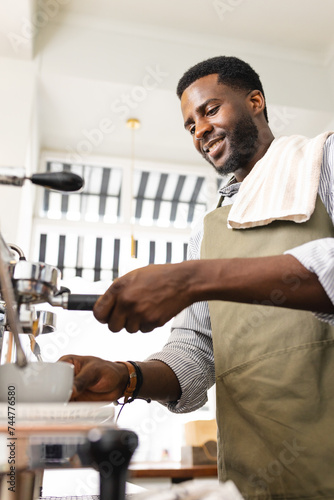 An African American barista prepares coffee at a cafe photo