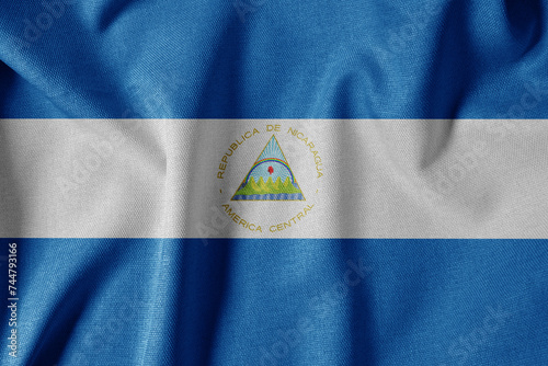 National Flag on Textured Fabric Background. Silk textured flag, realistic wave and flag look. NI Flag of Nicaragua