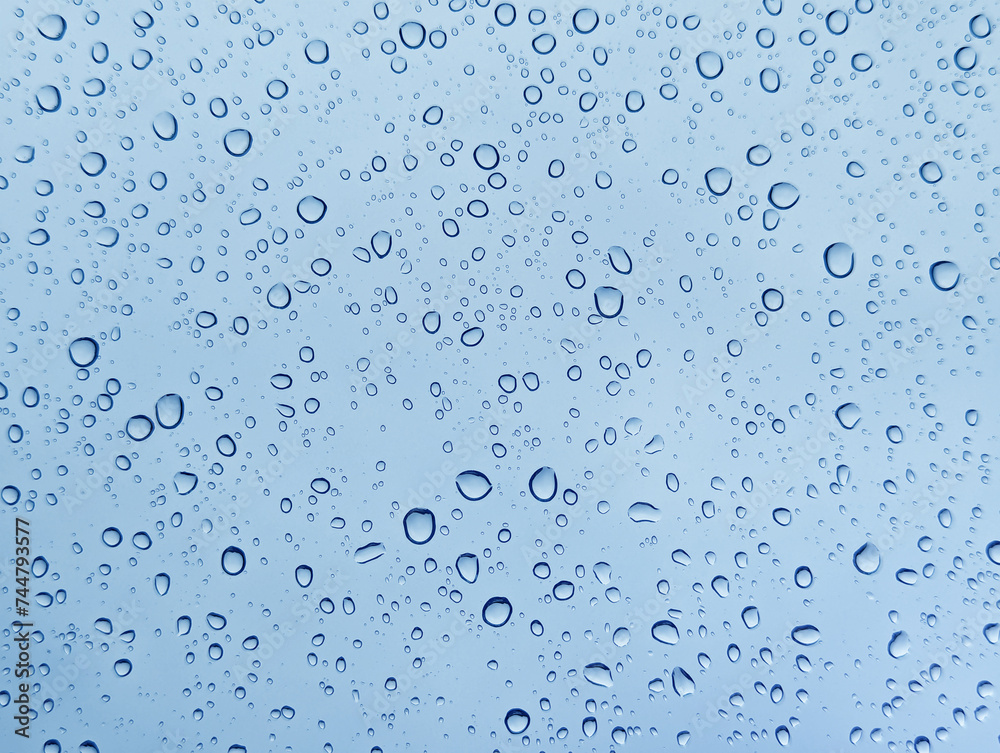Drops of rain on glass with blue background Drops of rain on glass with blue background