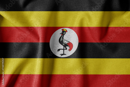 National Flag on Textured Fabric Background. Silk textured flag, realistic wave and flag look. UG  Flag of Uganda
