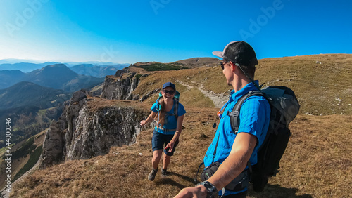Hiker couple on hiking trail to top of mountain peak Hohe Veitsch in Mürzsteg Alps, Styria, Austria. Panoramic view of alpine terrain. Wanderlust in remote Austrian Alps in autumn. Bonding experience