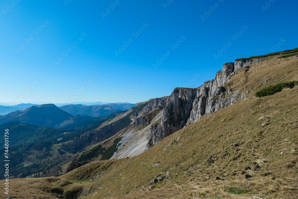 Fototapeta premium Panoramic view from top of mountain peak Hohe Veitsch in Mürzsteg Alps, Styria, Austria. Idyllic hiking trail in alpine terrain. Wanderlust remote Austrian Alps in autumn. Steep cliff rock formation