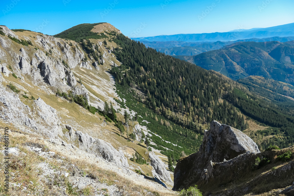Panoramic view from top of mountain peak Hohe Veitsch in Mürzsteg Alps, Styria, Austria. Idyllic hiking trail in alpine terrain. Wanderlust remote Austrian Alps in autumn. Steep cliff rock formation