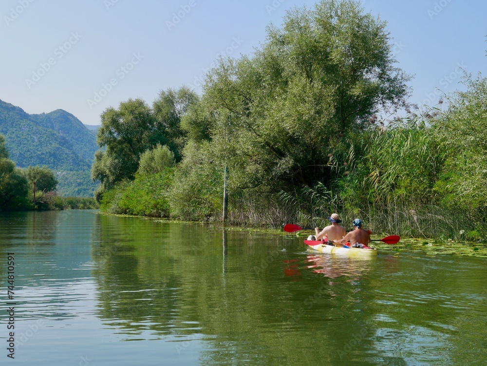 Kayaking on beautiful Skadar lake surrounded by green mountain peaks. Skadar Lake National Park, Montenegro. Kayaking on beautiful Skadar lake surrounded by green mountain peaks. Skadar Lake National Park, Montenegro.