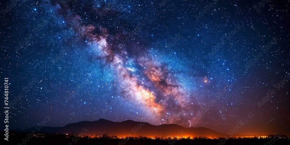 Breathtaking Night Sky with Milky Way Over Illuminated Landscape and Distant Mountains