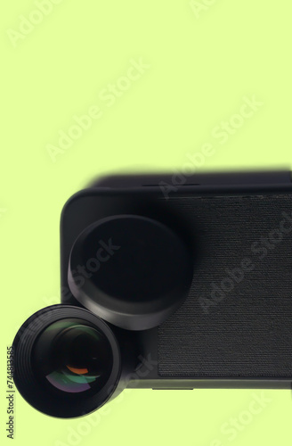 Tele lens for mobile potography on yellow background photo