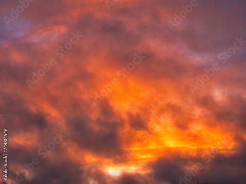Colorful sunset sky with dark and light color tone and rich orange red color. Nature background. Dramatic cloudscape.