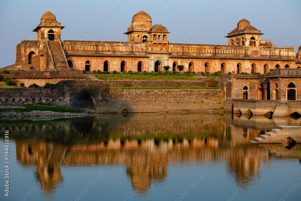 Fototapeta premium Jahaz Mahal , Ship Palace and blue water lake in sunrise. Mandu, Madhya Pradesh, India. Old Indian architecture on background
