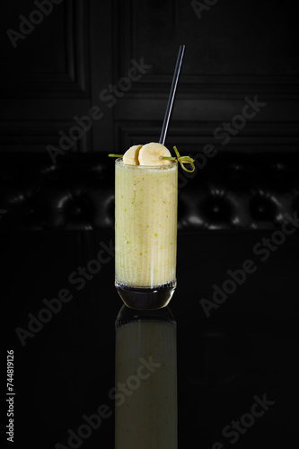 Celery and apple smoothie from green apple, fresh cucumber and celery salk in a glass with straw photo