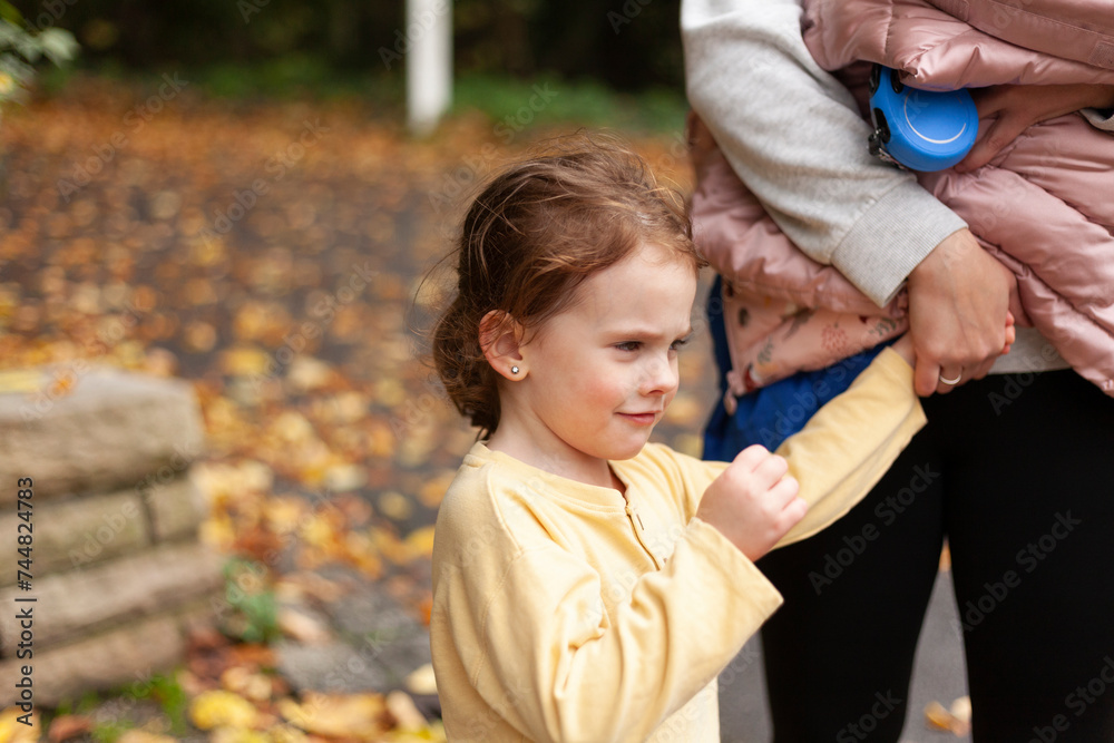 Little girl with her mother in autumn park. Selective focus. Little girl with her mother in autumn park. Selective focus.