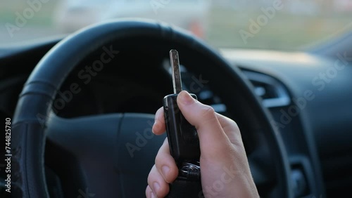 Driver pressing the button of an automatic car key, close-up photo