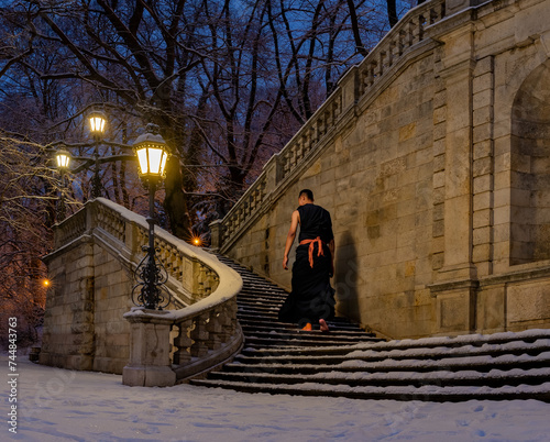 Light dressed monk walks in a cold winter night without freezing