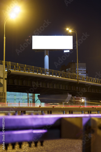 Tall large billboard near a road junction at night. Highway overpass night city. Mock-up.