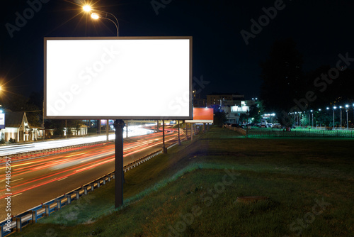 Billboard near the highway at night, heavy traffic. Mock-up.
