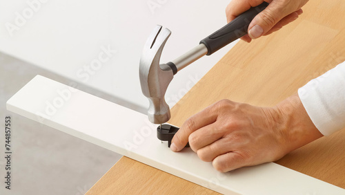 Closeup of person hammering a nail. (ID: 744857553)