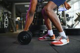Close-up of a man takes a dumbbell in the gym