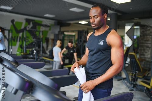 Sportive black man exercising on treadmill in fitness club