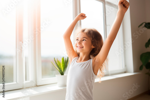 A joyful young girl stretching in the sunny comfort of her home.