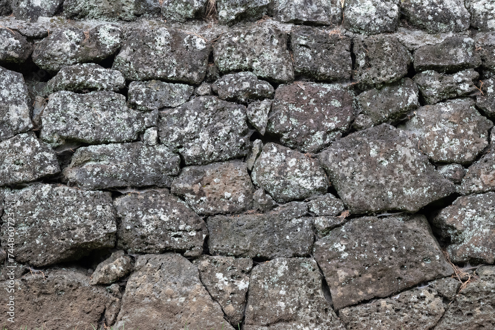 Old rock wall as a background pattern with moss covered stones