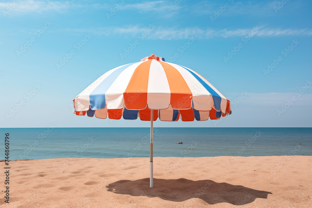 A colorful striped beach umbrella offers a relaxing spot by the tranquil ocean.