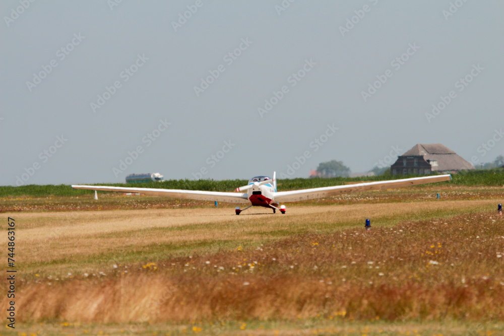 Fototapeta premium The motor glider on the runway during takeoff at Texel Airport