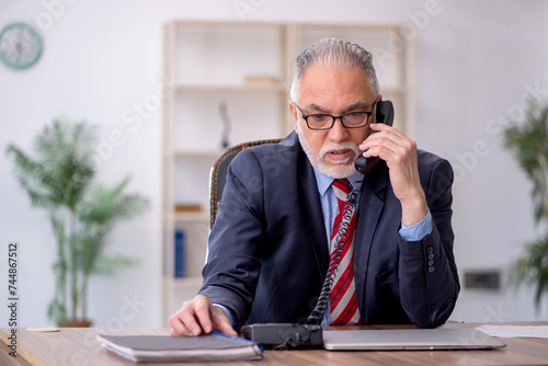 Old male employee working in the office