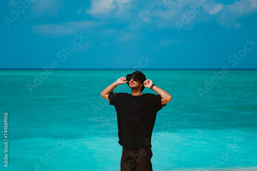 Serene Summer Escape: Stock Videos of a Man Relaxing on a Pristine Crystal-Clear Beach, Enjoying the Sun, Breeze, and Tranquil Tropical Paradise