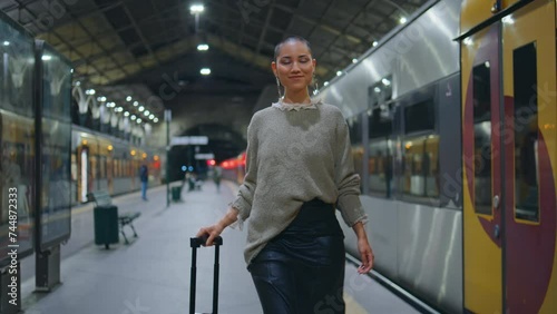 Trendy girl walking train station looking camera smiling. Short hair woman going
