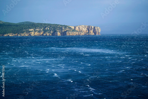 waves and rocks, Mistral storm in the gulf of Porto Conte, in the background the promontory of Punta Giglio, Alghero Sardinia, Italy photo