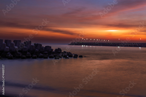 Stunning sunset blues hour view. Magnificent, beautiful breakwater, red cloudy sky form a scenic scene.High quality photo. Linyuan, Kaohsiung, Taiwan.For branding, screensavers, websites, postcard.