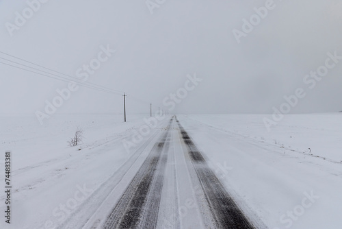 a snow-covered paved road in the winter season in a snowfall © rsooll