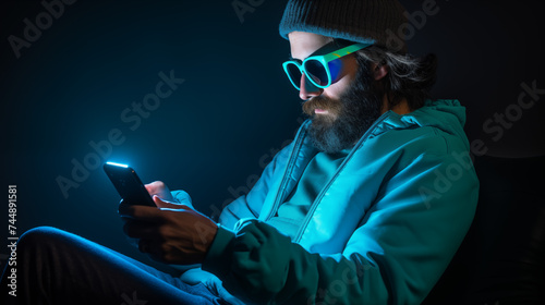 Junger Mann wird von Smartphone angestrahlt, Smombie, blaue Lichtstimmung