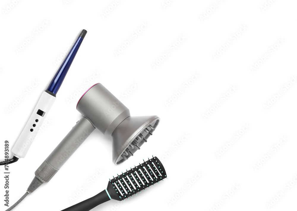 Hair dryer, curling iron and brush on white background, top view Hair dryer, curling iron and brush on white background, top view
