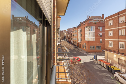 Fototapeta Naklejka Na Ścianę i Meble -  Views of an urban street with buildings with small balconies with metal railings