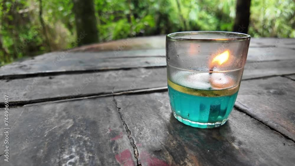 4k video footage of Oil lamps or kerosene lamp lantern with fire inside the glass on wooden table. Old traditional storm lamps. Liquid candle.