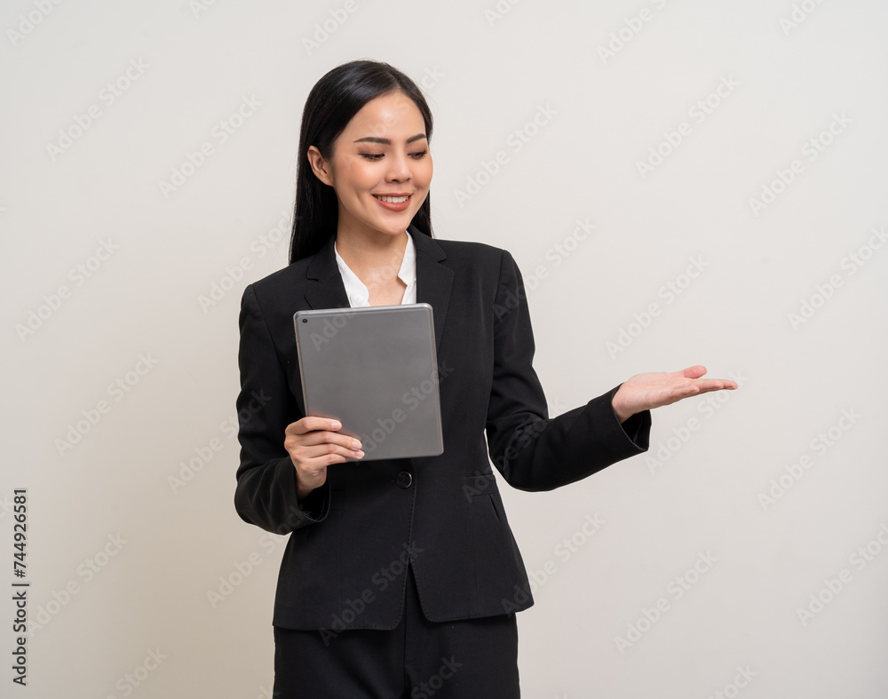 Attractive elegant young asian business woman using digital tablet standing on isolated background. Happy young latin female formal black suit holding tablet gadget working service with customer Attractive elegant young asian business woman using digital tablet standing on isolated background. Happy young latin female formal black suit holding tablet gadget working service with customer
