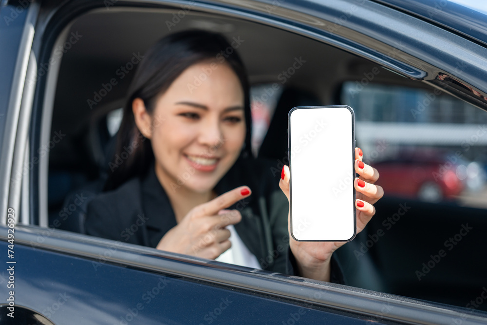 Young beautiful asian business women getting new car using smartphone. she very happy and excited. she showing cell phone screen application. Smiling female driving vehicle on the road downtown city