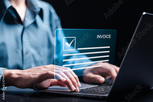 Invoice and online digital statements concept. Person using laptop with invoice document on virtual screen.