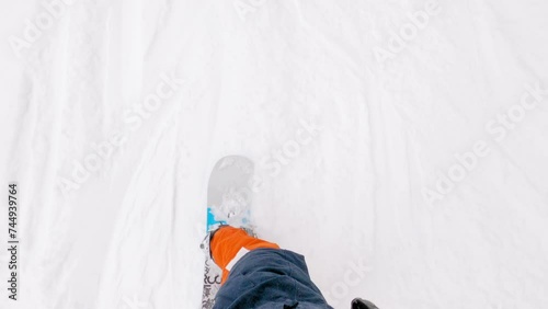 POV shot of a male snowboarder riding down the mountain
