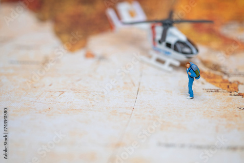 Miniature Traveler with Helicopter on World Map.