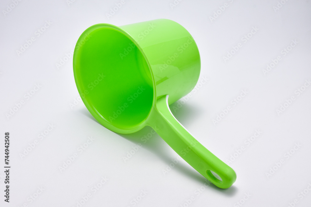 Green plastic ladle on a white background Green plastic ladle on a white background