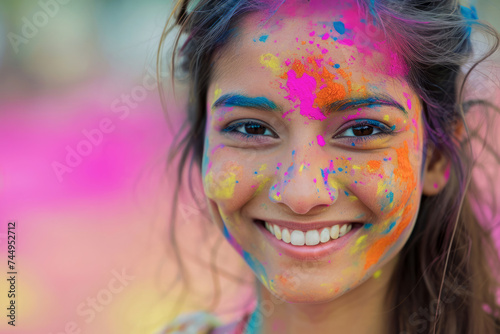 Closeup portrait of a girl covered with bright colourful powders during Holi celebration. 