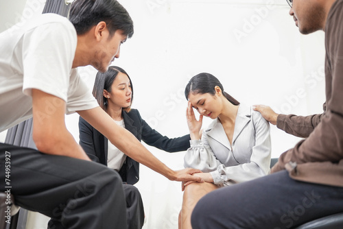 Group of Diverse asian people supporting desperate unhappy woman. Depressed female patient suffering from bullying, sharing personal problems at psychological therapy group meeting.