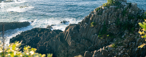 波が打ちつける柱状節理の岩